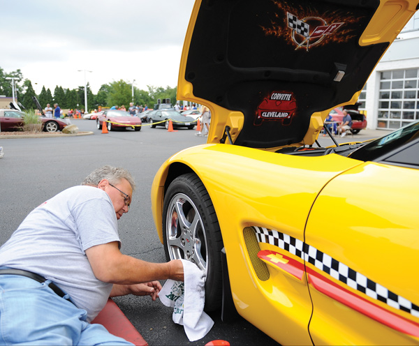 Warren Obert of Corvette Cleveland cleans the rims on his 2003 Corvette in the parking lot of the former Greenwood Hummer during the Corvette car show Sunday morning. This was the 20th year for the event sponsored by Greenwood Chevrolet and the Mahoning Valley Corvettes club.