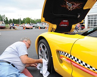 Warren Obert of Corvette Cleveland cleans the rims on his 2003 Corvette in the parking lot of the former Greenwood Hummer during the Corvette car show Sunday morning. This was the 20th year for the event sponsored by Greenwood Chevrolet and the Mahoning Valley Corvettes club.
