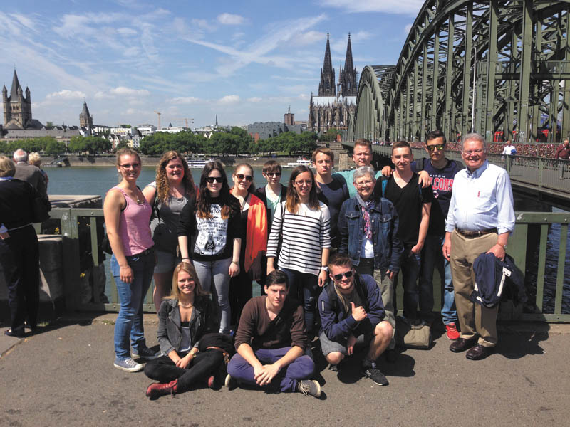 SPECIAL TO THE VINDICATOR
Local students visited Germany this summer as part of an exchange program. The Rhine River and Cologne Cathedral are in the background with students and their hosts. Sitting are German hosts Nadja Kappelar, left, Luca Klein and Michael Sartor. In back are Tabea Neff, host; Emily Henline of Austintown Fitch; Nina Knott, host; Jenna DeLaurentis of Boardman; Alex Apicella of Cardinal Mooney; Alina Domagala, host; Nathan Kalinay of Austintown Fitch; Sieglinde Warren, exchange coordinator; Harry Baumgartner, Austintown Fitch; Leon Breit and Robin Lorenz, hosts; and Larry Warren, exchange coordinator.
