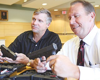 Girard Municipal Judge Jeffrey D. Adler, left, and Girard Police Chief Jeff Palmer look over new guns purchased
with court funds for the police department. Judge Adler allocated $10,500 from the fund for 22 .45-caliber
Glocks.