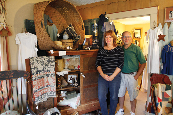 Joe and Linda Matulek stand near the wool basket and pie safe inside their antique shop, Cracked Crock in 
Canfield. The shop has a variety of items from furniture to antique christening gowns.