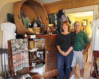 Joe and Linda Matulek stand near the wool basket and pie safe inside their antique shop, Cracked Crock in
Canfield. The shop has a variety of items from furniture to antique christening gowns.