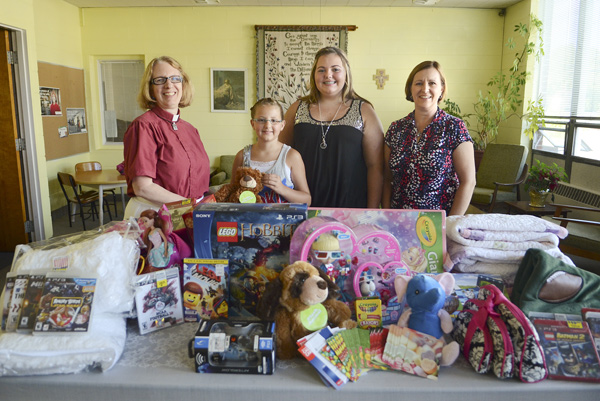Mariah Leskovac, 10, second from left, and her sister, Destiny, 13, third from left, created Mariah’s Destiny to collect donations of new items such as toys and games for sick children. The idea evolved from Mariah’s cancer diagnosis, treatment and recovery. The sisters received donations at their church, Trinity Lutheran in Niles, where the Rev. Dee Emmert, left, is pastor. Accepting donations is Sue Neitz, right, stem-cell transplant coordinator at Akron Children’s Hospital.