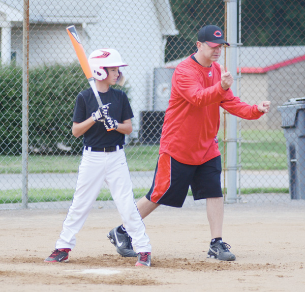 Jake Kowal of the Canfield 11-12 Little League baseball team listens to instructions from his coach George Beck at Wednesday’s practice. The team is headed to the Great Lakes Regional Tournament in Indianapolis on Saturday after winning the state title last weekend in Cambridge.