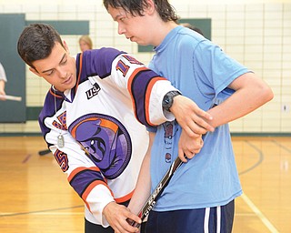 Tommy Parran, left, a Youngstown Phantoms hockey player, gives some pointers to Matthew Hipple, 17, of Youngstown at Camp FRIEND, which stands for Finding Rewards in Every New Day.
