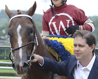 Katie Rickman | The Vindicator.Tapiture and his jockey Rosie Napravnik are led off the track by owner Ron Winchell after winning the West Virginia Derby August 2, 2014.