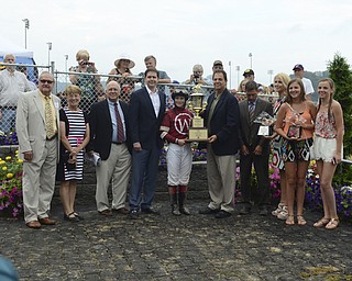 Katie Rickman | The Vindicator.Owners and Jockey Rosie Napravnik hold up and award and pose for a photo after winning the West Virginia Derby August 2, 2014.
