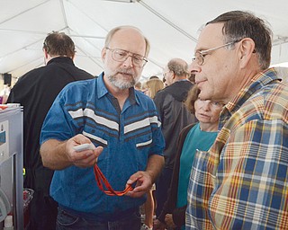 Joe Revesz of Turning Technologies, left, shows Rick and Karen France of Howland how a 3-D printer works at the final Maker City event Sunday. France is an industrial technology teacher at Badger High School and will soon be working with 3-D printers at the school.