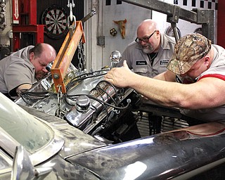 The crew at Christmas Automotive replaces an engine in a scene from “Fat ’N Furious.” From left are Chuck Kountz, Tommy Christmas and Steve McGranahan. The show’s strong finish in the ratings earned it a renewal for a second season.