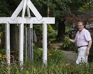 ROBERT K. YOSAY | THE VINDICATOR.. CHIMES made from piping grace the gardent -Father Dave's dad was plumber and pipefitter..Our Lady of the Lakes Parish-- has an oasis for solitude or just reflection or just enjoying the flowers as the Rev. David W. Merweiler is pastor and gardener..... -30-