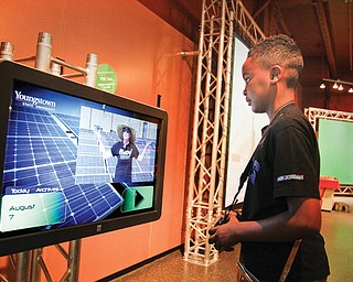 Demar Clark, 11, of Youngstown watches a solar-power energy graphic showing panels atop a Youngstown State University building that provide electricity. The graphic also charts how much is produced at any given hour. Thanks to the Internet, Demar gets to watch the progress from a mile away at the OH WOW! science and technology center in downtown Youngstown.