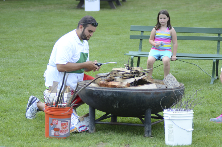 Katie Rickman | The Vindicator.Jordan Vigorito, a Mill Creek MetroParks staff member lights a fire as Kelsie Rudolph, 7, of Boardman watches August 9 ,2014.