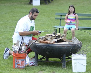 Katie Rickman | The Vindicator.Jordan Vigorito, a Mill Creek MetroParks staff member lights a fire as Kelsie Rudolph, 7, of Boardman watches August 9 ,2014.