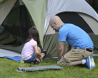 Katie Rickman | The V indicator.Peyton Arn, 4 of Boardman helps her father Ben Arn put their tent up at Family Camp at Mill Creek MetroPark August 9, 2014.