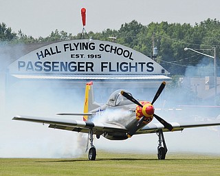 Jeff Lange | The Vindicator  The "Mustang Mama" a T-51 Mustang goes down the runway in a cloud of smoke before liftoff at the Ernie Hall Aviation Museum in Warren, Saturday afternoon.