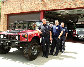 The Austintown Fire Department has obtained a surplus military vehicle and converted it to a brush-fire truck and rescue/EMS for off-pavement situations in the township. Firefighters, from left, Keith Rosser, Bill Palkovic, and Dave Schertzer stand in front of the 1992 Humvee.