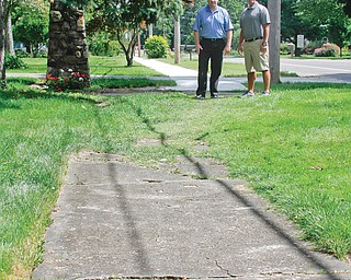 Poland Village Mayor Tim Sicafuse, left, and Poland Township Trustee Eric Ungaro look over the sidewalk that needs to be upgraded to finish a program funded by a grant called Safe Routes to School. The township received $500,000 to build new sidewalks to tie into the village’s sidewalks, but now there is a 200-foot gap between the sidewalks, above. Both township and village officials would like to see the section fixed.