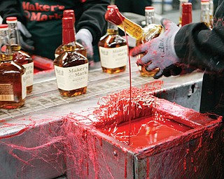 A bottle of Maker’s Mark bourbon is dipped in red wax during a tour of the distillery in Loretto, Ky. Kentucky bourbon makers have stashed away their largest stockpiles in more than a generation due to resurgent demand
for the venerable brown spirit.