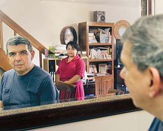 Nathan Rivera of Austintown looks at a reflection of himself and his wife, Elizabeth, in their home. Before surgery, Rivera struggled with Parkinson’s for a year.