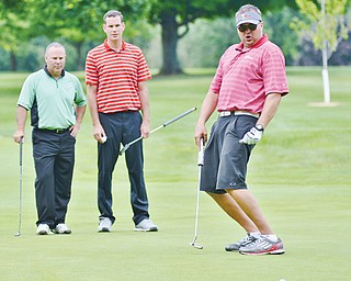 Eric Ryan of Struthers, right, watches as his putt slides wide of the hole at The Lake Club in Poland on Monday during the 2nd Annual Greatest Scramble championship. His teammates watch in the distance.