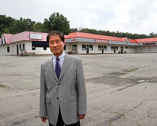 Moon Park, owner of the strip plaza directly across the street from Hollywood Gaming at Mahoning Valley Race Course, stands in front of his vacant property in Austintown. His property is for sale, lease or investment and sits on 3.2 acres at Silica Road and state Route 46.