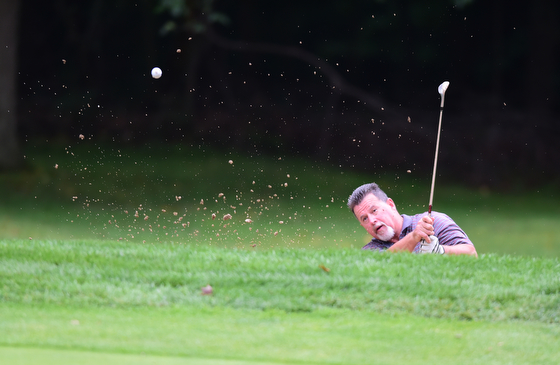 BOARDMAN, OHIO - AUGUST 22, 2014: John Thompson of Palm Creek, Florida shoots his ball out of the sand trap and onto the green on the 18th hole on the south course Friday morning at Mill Creek Golf Course during the Vindy Greatest Golfer Tournament. (Photo by David Dermer/Youngstown Vindicator)