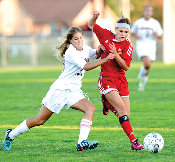 Boardman’s Alison Green makes contact with Cardinal Mooney’s Brooke Overly during Monday’s game in Boardman. The Spartans won, 7-6.