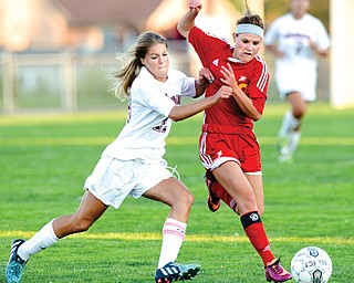Boardman’s Alison Green makes contact with Cardinal Mooney’s Brooke Overly during Monday’s game in Boardman. The Spartans won, 7-6.