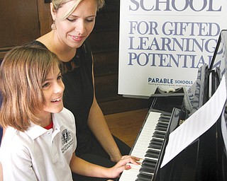Sara Reichard, director of the Lewis School for Gifted Learning Potential, sits at the piano with her daughter, Maria Reichard, 9, in the school inside Trinity United Methodist Church in downtown Youngstown. The school opens next Tuesday.