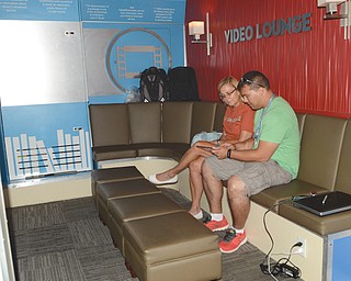 Pablo Chois of Cleveland helps Sally Rahde of Canfield with a portable e-book downloading and reading device Tuesday in the OverDrive Bookmobile’s video lounge. The bookmobile, which tours the United States and Canada, made a six-hour stop at the Boardman library. 