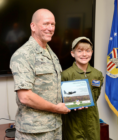 Col. David Post (left) and Christian Abrigg (13) of Canfield stand with his certificate for Pilot for a Day, Wednesday before the Air Force base tour.