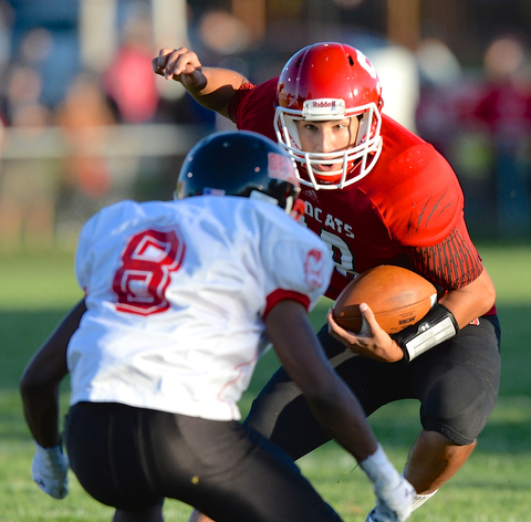 Jeff Lange | The Vindicator  Struthers starting quarterback A.J. Musolino (right) jukes past the defense of Campbell's Isiah Williams during first quarter action in Struthers, Thursday night.