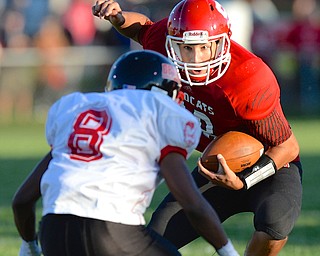 Jeff Lange | The Vindicator  Struthers starting quarterback A.J. Musolino (right) jukes past the defense of Campbell's Isiah Williams during first quarter action in Struthers, Thursday night.