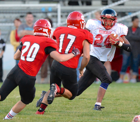 Jeff Lange | The Vindicator  Campbell's Mike Willim rushes for yardage past the defense of Struthers' Robbie Best (far left) and Andy Deem (center) in first half action, Thursday night in Struthers.