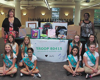 Dustin Livesay | The Vindicator: Standing are Patricia Johnston, left, of the Summit Academy of Warren and Audrey Walker, right, of the Sojourner House of Youngstown as they receive school supplies collected by the eight members of Poland Girl Scouts Troop 80415 for the students at the two schools. The Scouts are, from left in front, Haley Trolio, Chryssa Papakirk, Mary Liddle and Anna Simeon and, from left in back, Laural Zarbaugh, Molly Malner, Emma White and Grace Economus. 