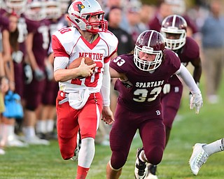 BOARDMAN, OHIO - AUGUST 29, 2014: Quarterback Jake Floriea #10 of Mentor runs down the sideline for a big gain after getting past linebacker Evan Croutch #33 and defensive back Marcus Smith #7 of Boardman during the 2nd quarter of Friday nights OHSAA football game at Boardman Spartans Stadium. (Photo by David Dermer/Youngstown Vindicator) Linebacker Bradie Crandell #46 pictured.