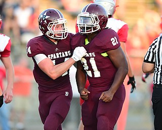 BOARDMAN, OHIO - AUGUST 29, 2014: Running back Benji Roberts #21 of Boardman is congratulated by teammate Matt Filipovich #14 after scoring a touchdown during the 1st quarter of Friday nights OHSAA football game at Boardman Spartans Stadium. (Photo by David Dermer/Youngstown Vindicator) Linebacker Bradie Crandell #46 pictured.