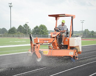 Ron Evans of Tron Sport Turf Installation out of Pennsylvania sweeps the track at Boardman High School. Installation of new turf at the sports facility off Nisonger Road on the high school’s campus was completed Monday.