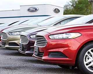 A row of new 2013 Ford Fusions are displayed at an automobile dealership in Zelienople, Pa. As the auto industry strives to sustain its post-recession comeback, car companies are resorting to tactics that some experts warn will lead to trouble down the road.