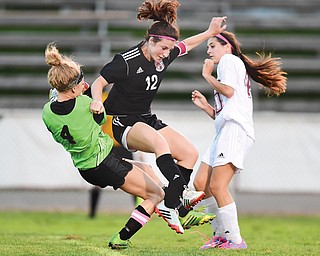 Canfield’s Sophia Mancini (12) collides mid-air with Boardman goalie Kristen Huck (4) during the first half of their game Wednesday at Spartans Stadium in Boardman. The Cardinals defeated the Spartans, 4-2.