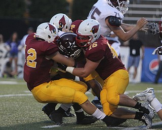 Boardman's Benji Roberts (21) gets wrapped up behind the line of scrimmage by a swarm of Cardinal Mooney defenders led by Andrew Armstrong (12) and Alex Sepesy (16) during the first quarter of Friday nights matchup at Stambaugh Stadium on the campus of Youngstown State University.  Dustin Livesay  |  The Vindicator  09/05/14  YSU.