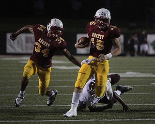 Cardinal Mooney quarterback Jon Saadey (15) picks up a block by his running bacl Jordan Jones (34) on shaking him loose of a tackle by Boardman's Erick Ritz during the second quarter of Friday nights matchup at Stambaugh Stadium on the campus of Youngstown State University.  Dustin Livesay  |  The Vindicator  09/05/14  YSU.