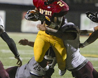 Cardinal Mooney running back C.J. Amill (2) tries to jump through a hole but is wrapped up by Boardman's Mario Graziana (25) and Erick Ritz (43) during the second quarter of Friday nights matchup at Stambaugh Stadium on the campus of Youngstown State University.  Dustin Livesay  |  The Vindicator  09/05/14  YSU.