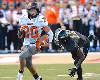 Jeff Lange | The Vindicator  Howland's quarterback Victor Williams keeps the ball as he rushes for a first down late in the second quarter against Harding in Warren. Harding's Hasan Muhammad trails the play from behind