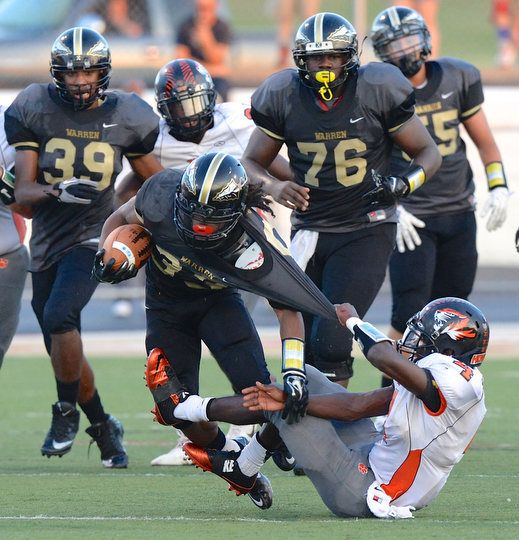 Jeff Lange | The Vindicator  Howland's Juwan Pringle pulls Keemari Murry to the ground as he rushes for yardage in first half action at Mollenkopf Stadium in Warren, Friday night.