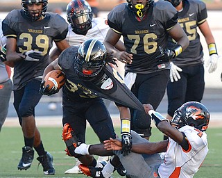 Jeff Lange | The Vindicator  Howland's Juwan Pringle pulls Keemari Murry to the ground as he rushes for yardage in first half action at Mollenkopf Stadium in Warren, Friday night.