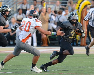 Jeff Lange | The Vindicator  Harding's Elijah Cofield (right) rushes to the sideline past Howland defender Victor Williams (20). Harding's Parker Stanislaw trails the play from the left.