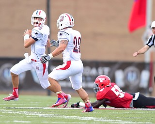 YOUNGSTOWN, OHIO - SEPTEMBER 6, 2014: Quarterback Dillon Buechel #5 of Duquesne slips the tackle from defender Terrell Williams #59 while looking downfield for running back Ryan Ho #22 during the 4th quarter of Saturday afternoon game at Stambaugh Stadium. YSU won 34-23. (Photo by David Dermer/Youngstown Vindicator)