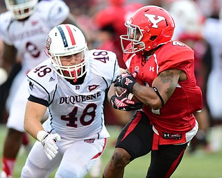 YOUNGSTOWN, OHIO - SEPTEMBER 6, 2014:  Receiver Andre Stubbs #4 of YSU is about to be tackled by defender Sam Martello #48 of Duquesne during the 4th quarter of Saturday afternoon game at Stambaugh Stadium. YSU won 34-23. (Photo by David Dermer/Youngstown Vindicator)