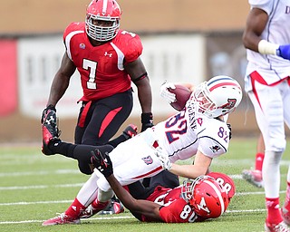 YOUNGSTOWN, OHIO - SEPTEMBER 6, 2014: Receiver Bobby Gustine #82 of Duquesne is drug down by Andrew Williams and Desmond Williams on a punt return during the 4th quarter of Saturday afternoon game at Stambaugh Stadium. YSU won 34-23. (Photo by David Dermer/Youngstown Vindicator)